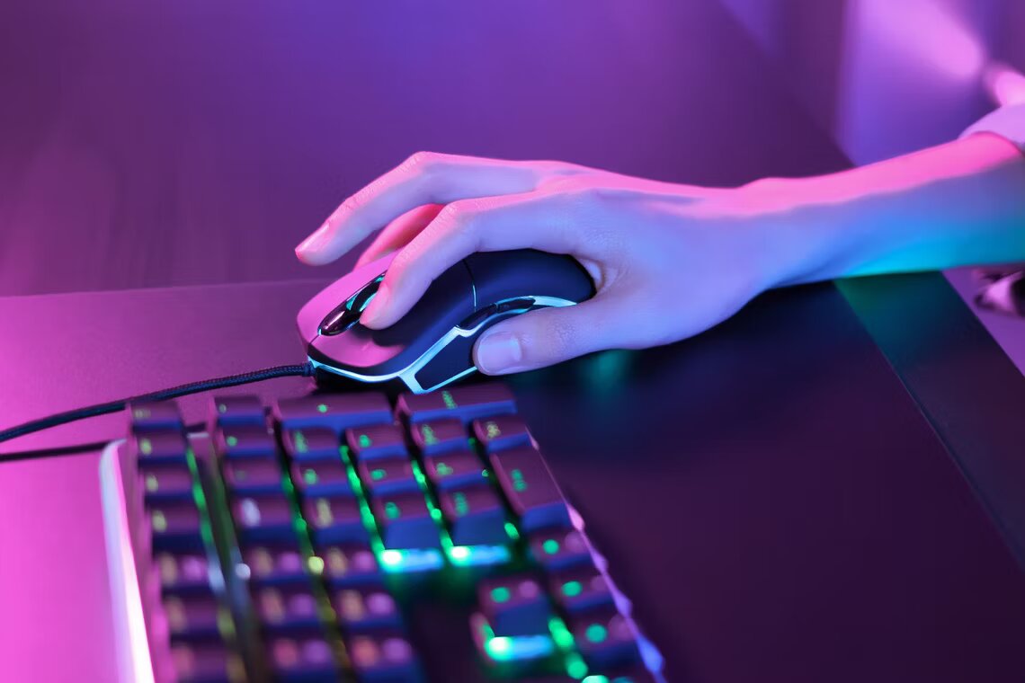 person-using-a-gaming-mouse-under-pink-neon-lights-next-to-an-rgb-keyboard.jpg